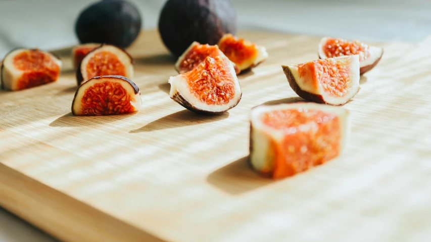 sliced figs sitting on a  board and with one cut in half