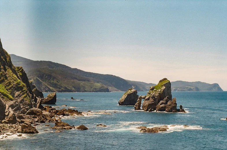 there are rocks on the edge of a cliff overlooking the ocean