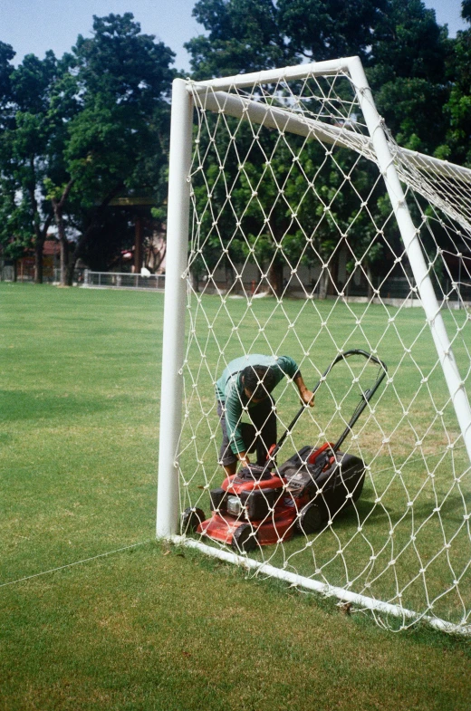 a man kneeling on the grass, playing soccer