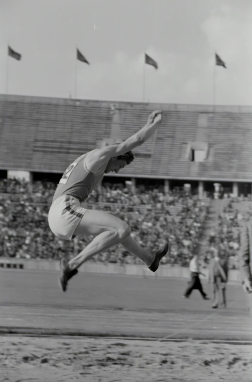 a man jumping up in the air to land a long jump