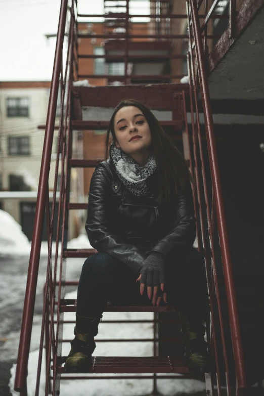 a  sitting on the steps of a building in winter