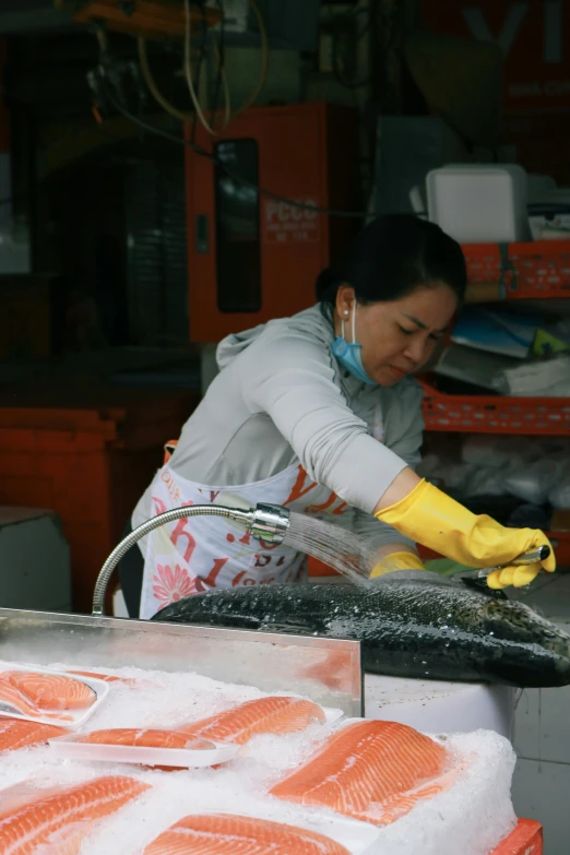 a woman with a pair of gloves and some fish