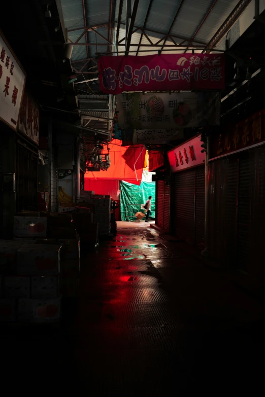 a narrow alley with a sign and red lights hanging overhead