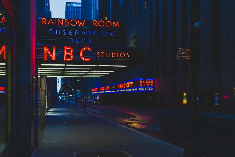 city night time scene with neon lights, signs and the broadway theatre