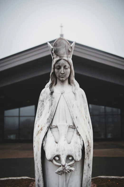 a statue depicting a cat with a woman's face and two eyes on the head