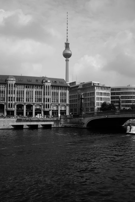 black and white po of bridge over water with skyline behind