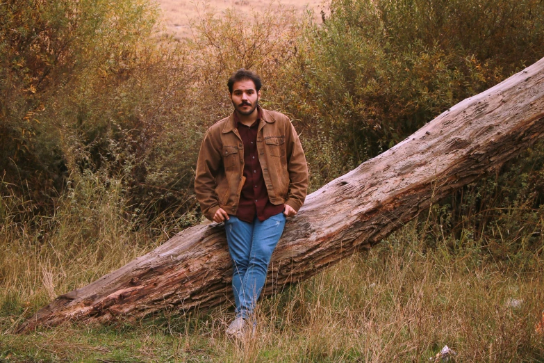 a man standing in front of a fallen tree