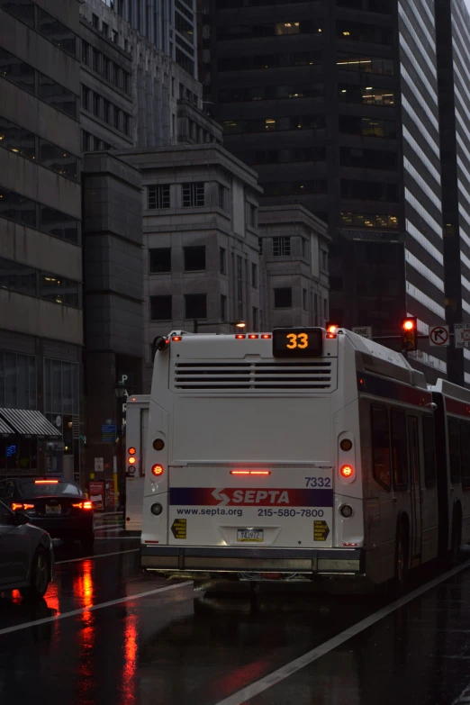 bus stopped at traffic light on a rainy city street