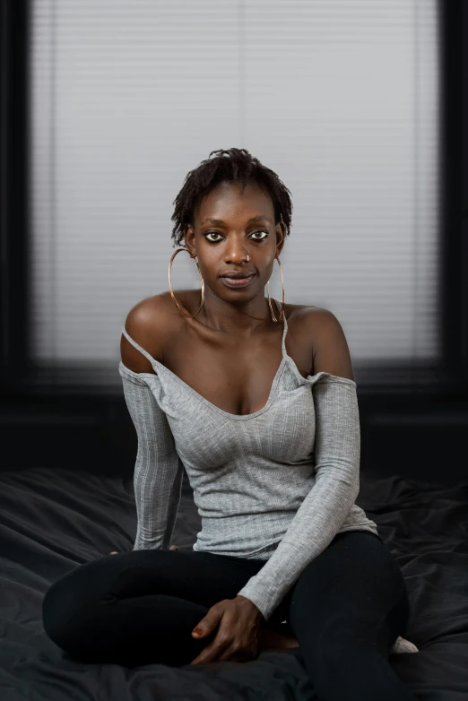 a woman sitting on a bed with one leg up