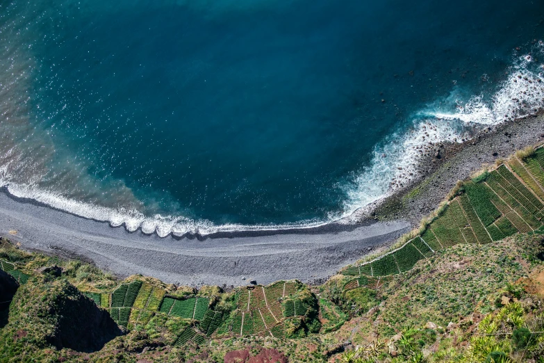 an aerial view of the ocean and sandy beach