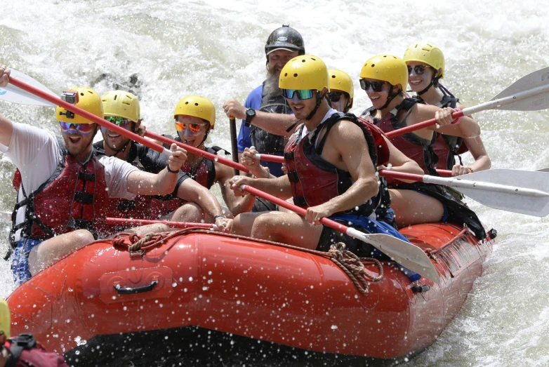 a group of people in an inflatable boat riding through rapids