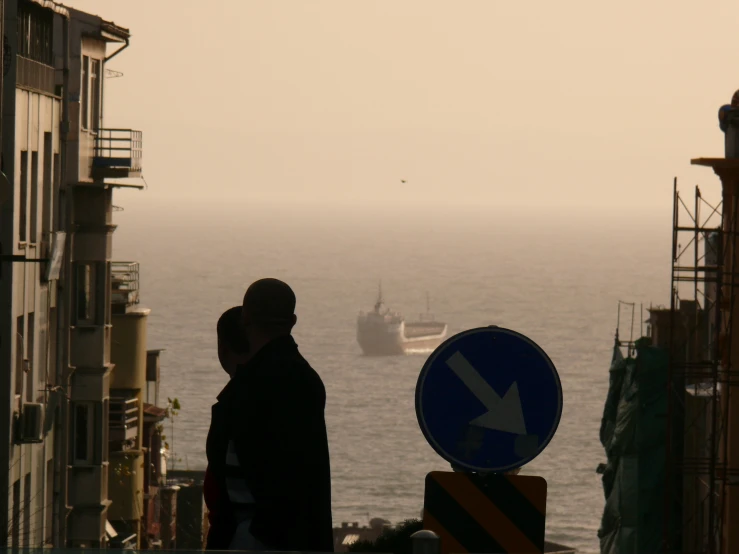 a couple of people standing next to a large ship