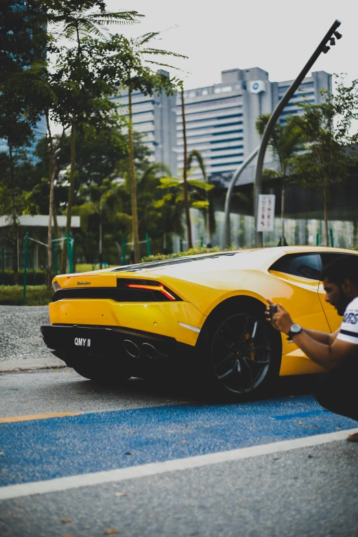 the man is fixing the tires on the yellow sports car