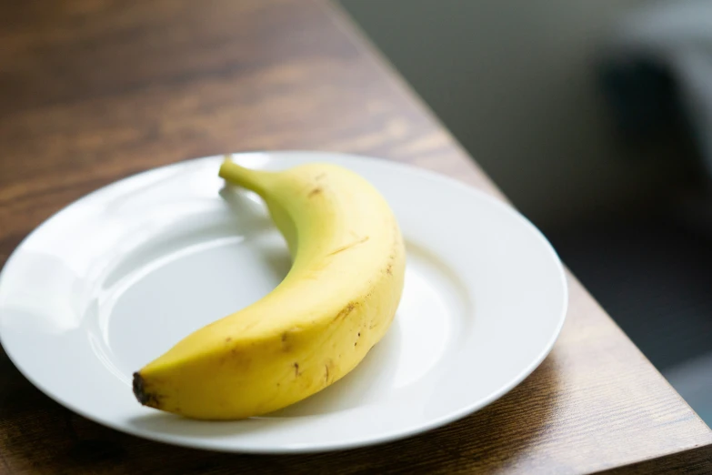 the plate is on a table with a banana