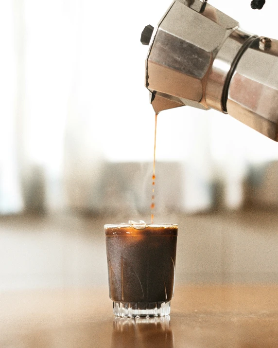 someone is preparing their own beverage in a coffee maker