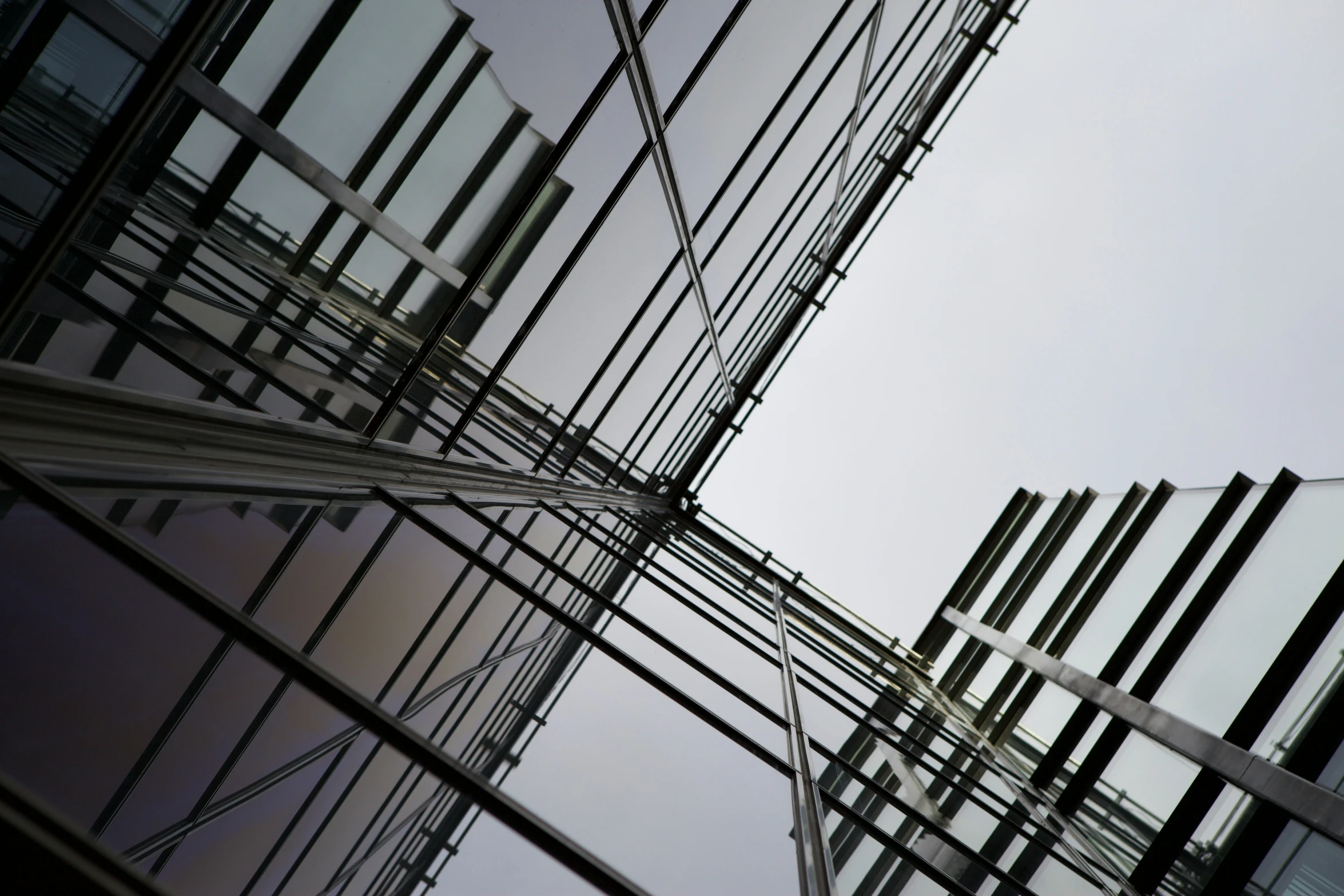 a high rise building has glass windows and wires