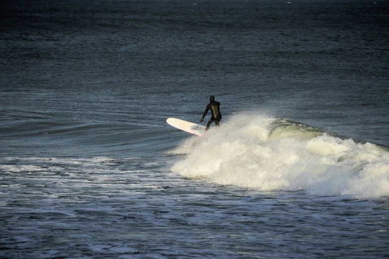 a person in the ocean with a surfboard riding a wave