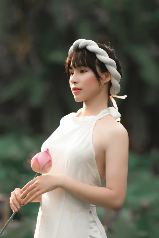 a beautiful young lady holding a rose and metal spoon