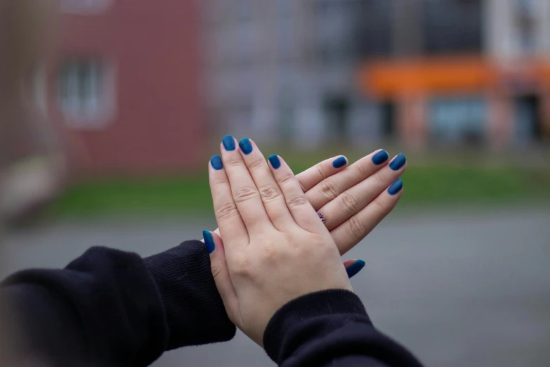 a woman standing on top of a street holding her hands up