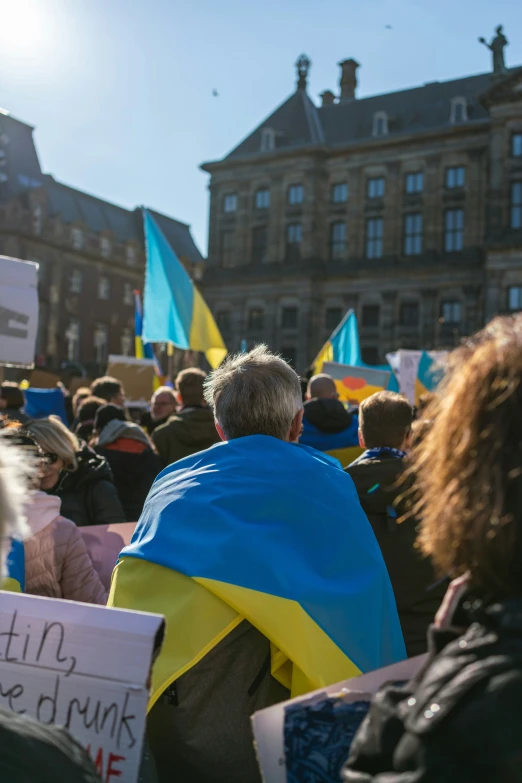 a crowd of people holding flags and signs