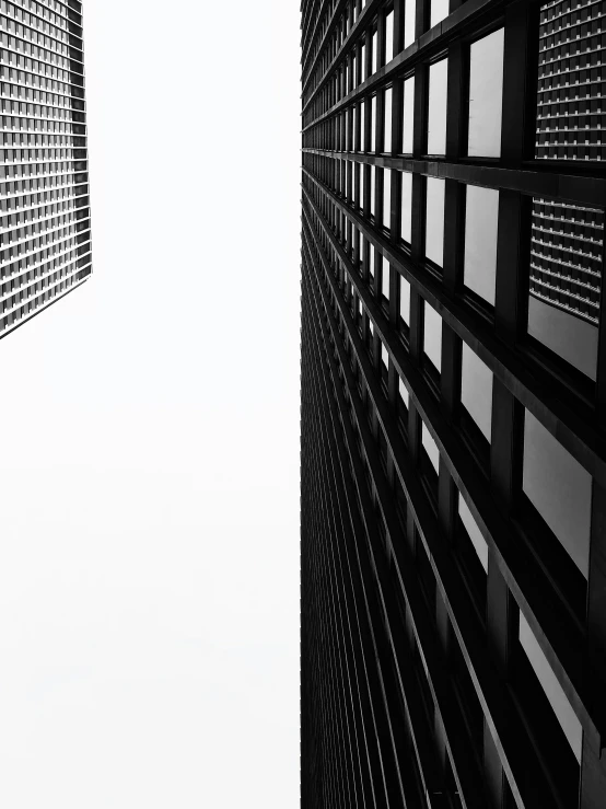 two tall buildings are shown from below in the sky