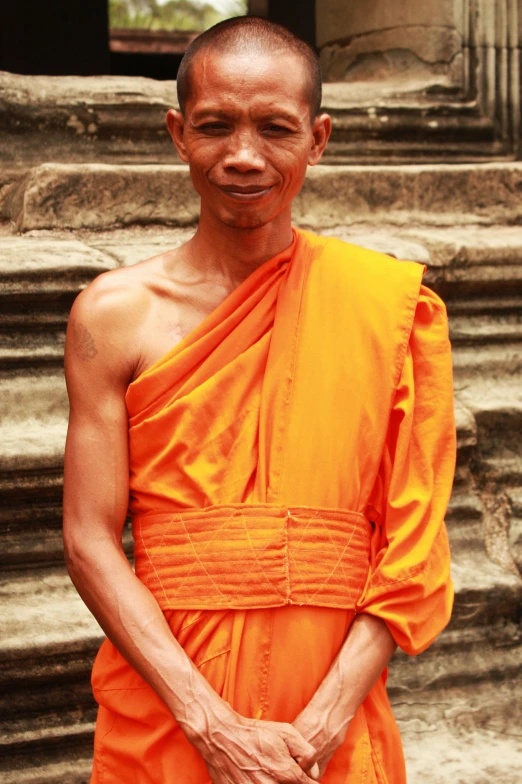 a man with shaved head standing in front of steps