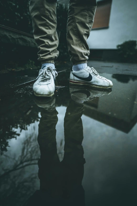 a person stands in the water with their shoes up