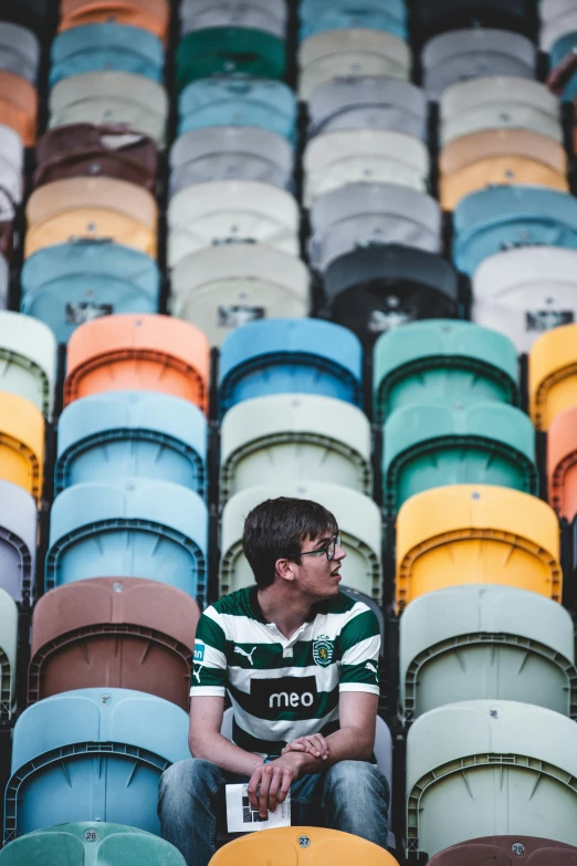 a young man sits in a football stadium