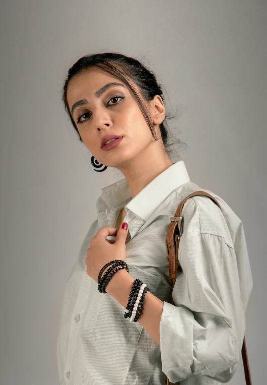 a woman wearing a bag posing with her hand on her chest