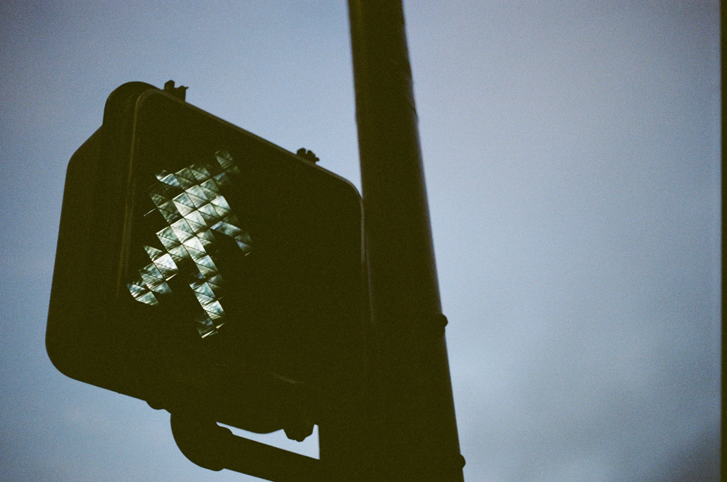 the back side of a stoplight and street sign with an artistic crosswalk pattern