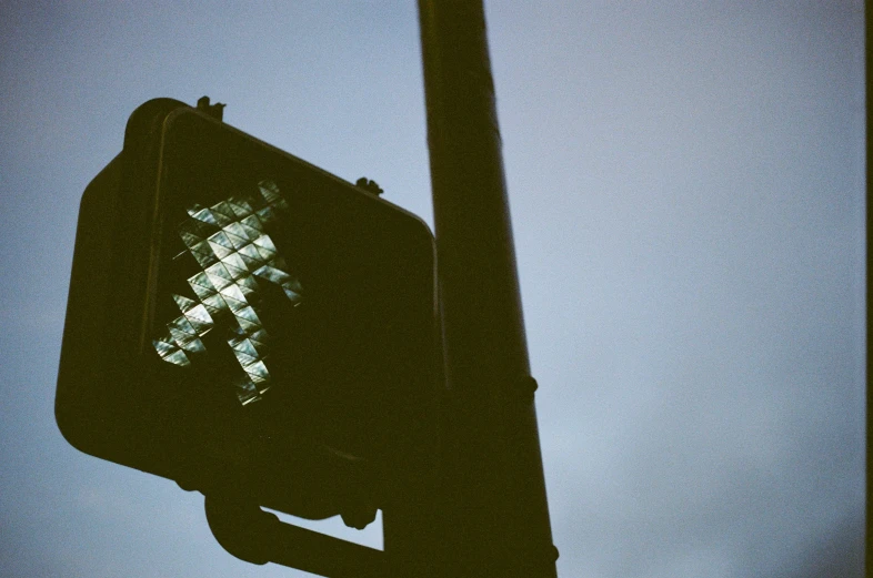 the back side of a stoplight and street sign with an artistic crosswalk pattern