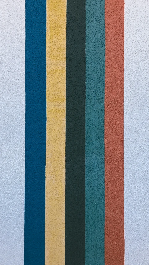 multi - colored vertical stripes of fabric against a white wall