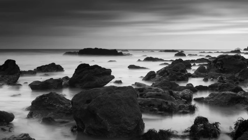 the rocks are in water near the shore