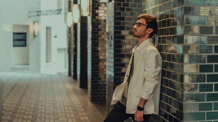 the man leans against the wall in a building