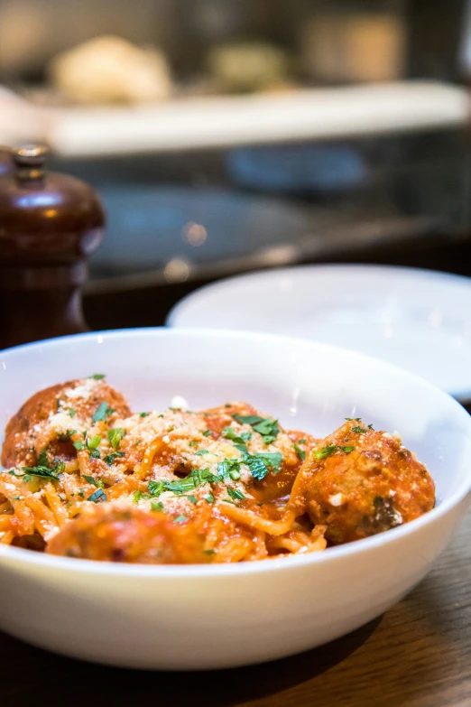 a bowl of spaghetti with a wooden plate