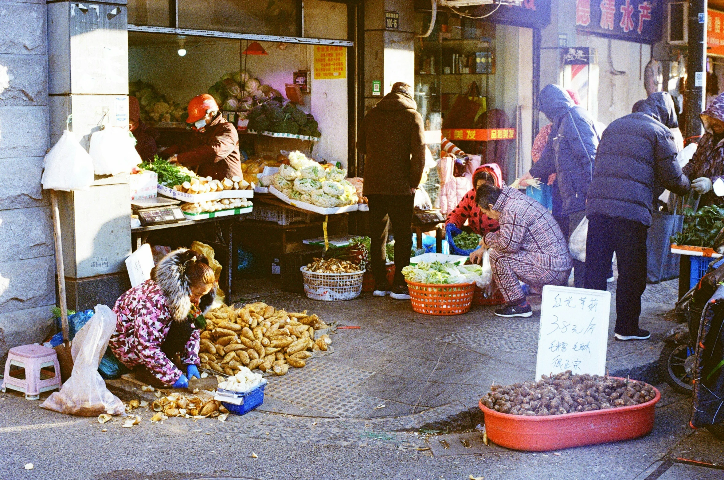 people are in a market with a variety of fruit and vegetables