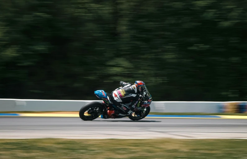 a man riding on the back of a motorcycle down a road