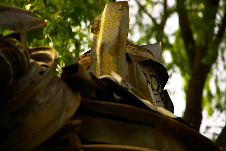 an old weathered iron object sits next to some trees