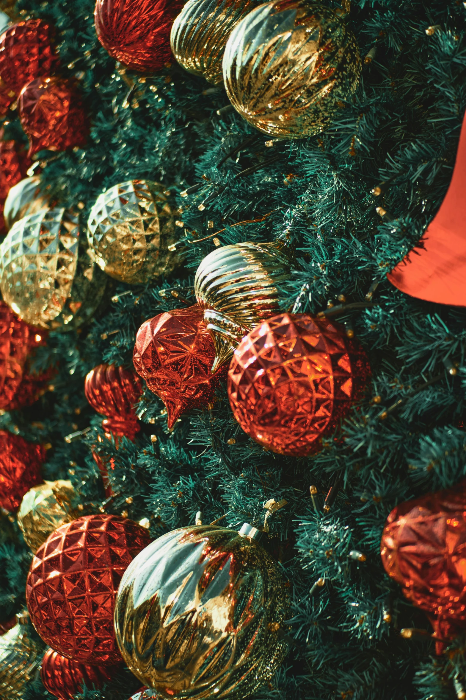 many golden and red ornaments are hanging from the tree