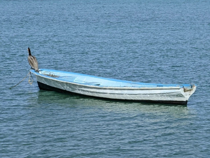 the small white boat is in the middle of the water