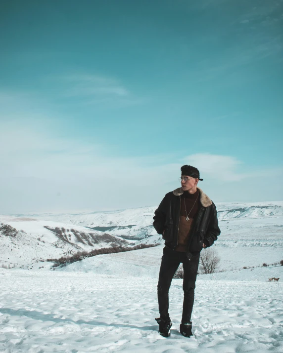 a man standing in the snow with his hat on