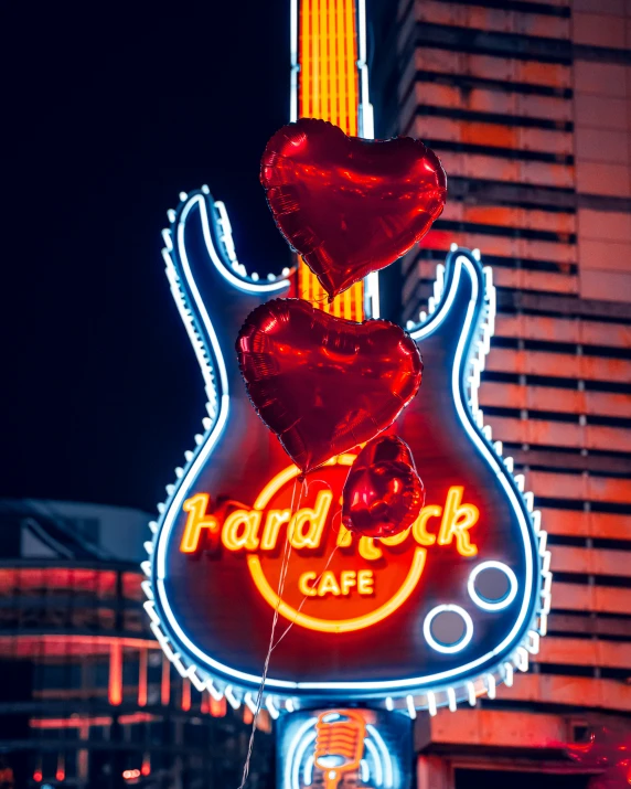 a neon sign in the shape of a guitar that reads hard rock cafe