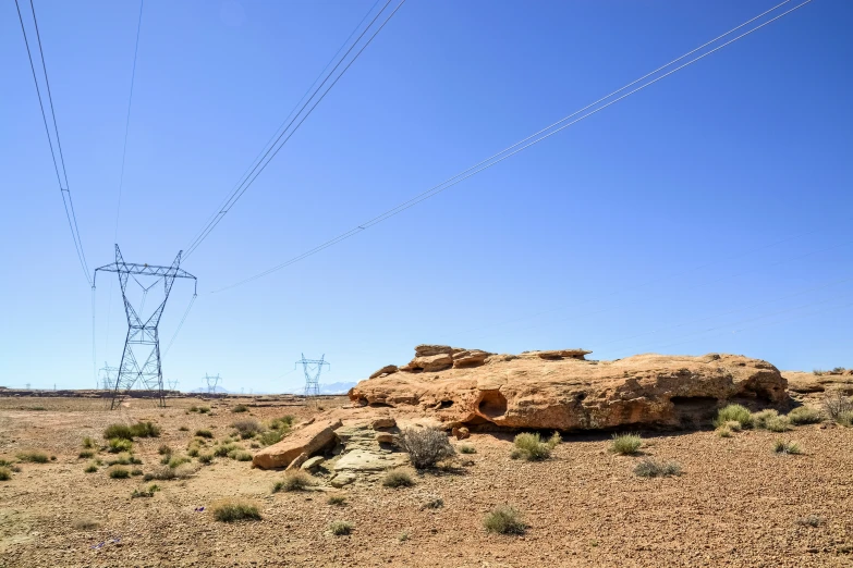 an open field with many power lines in the background