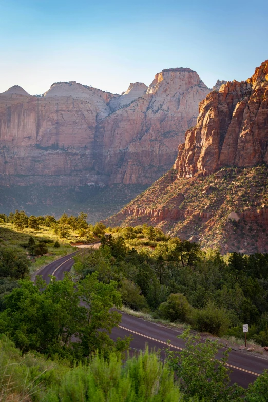 a road going through the mountains in the sun