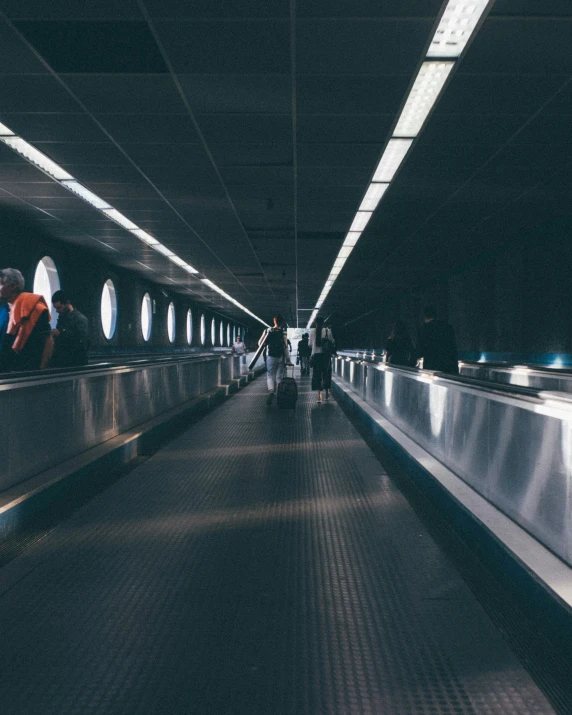 a train station has people on the escalators