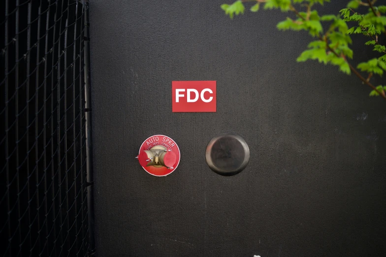 a black wall with various colored stickers and a fdo sign