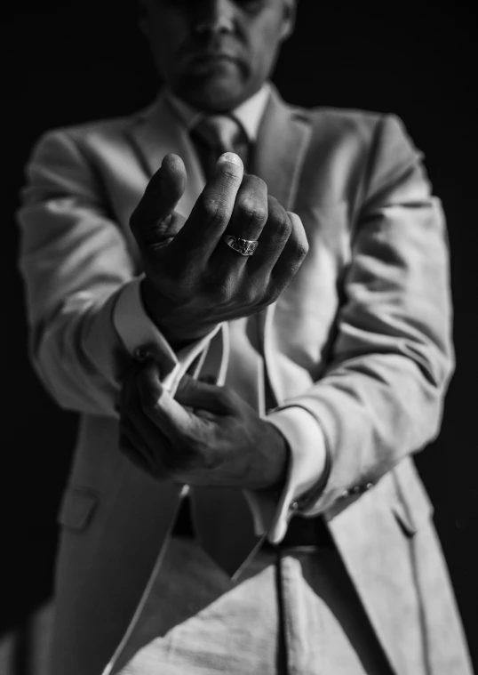 a man wearing a suit and tie pointing his finger at soing