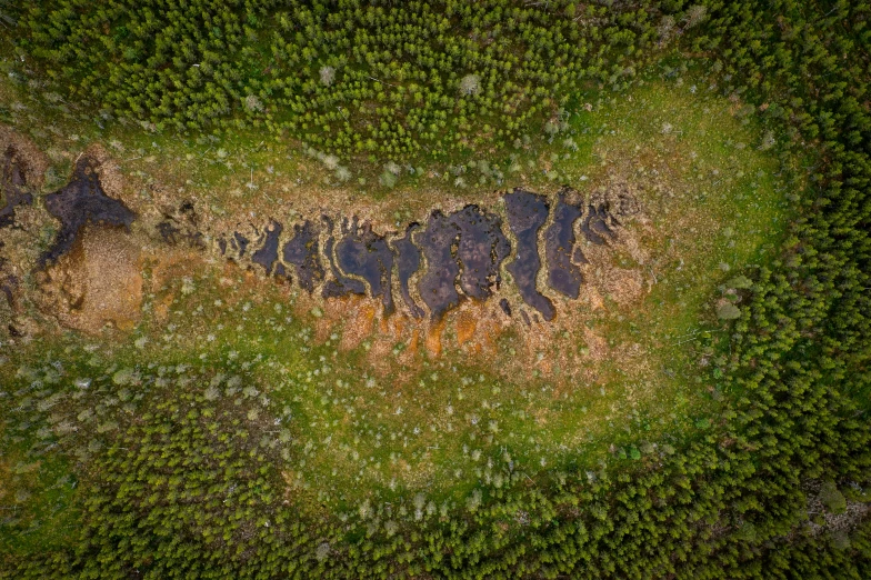 an aerial po of a large rock formation in some grass