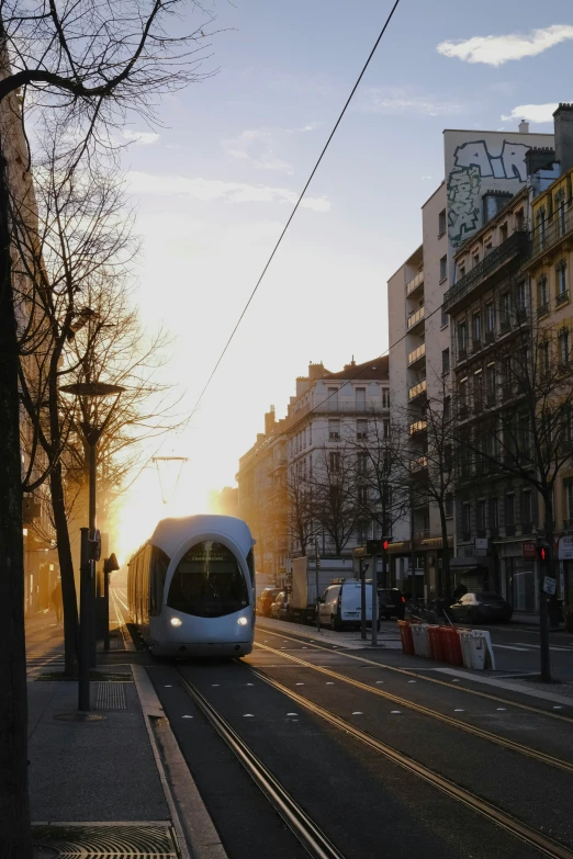 an electric train in front of some buildings