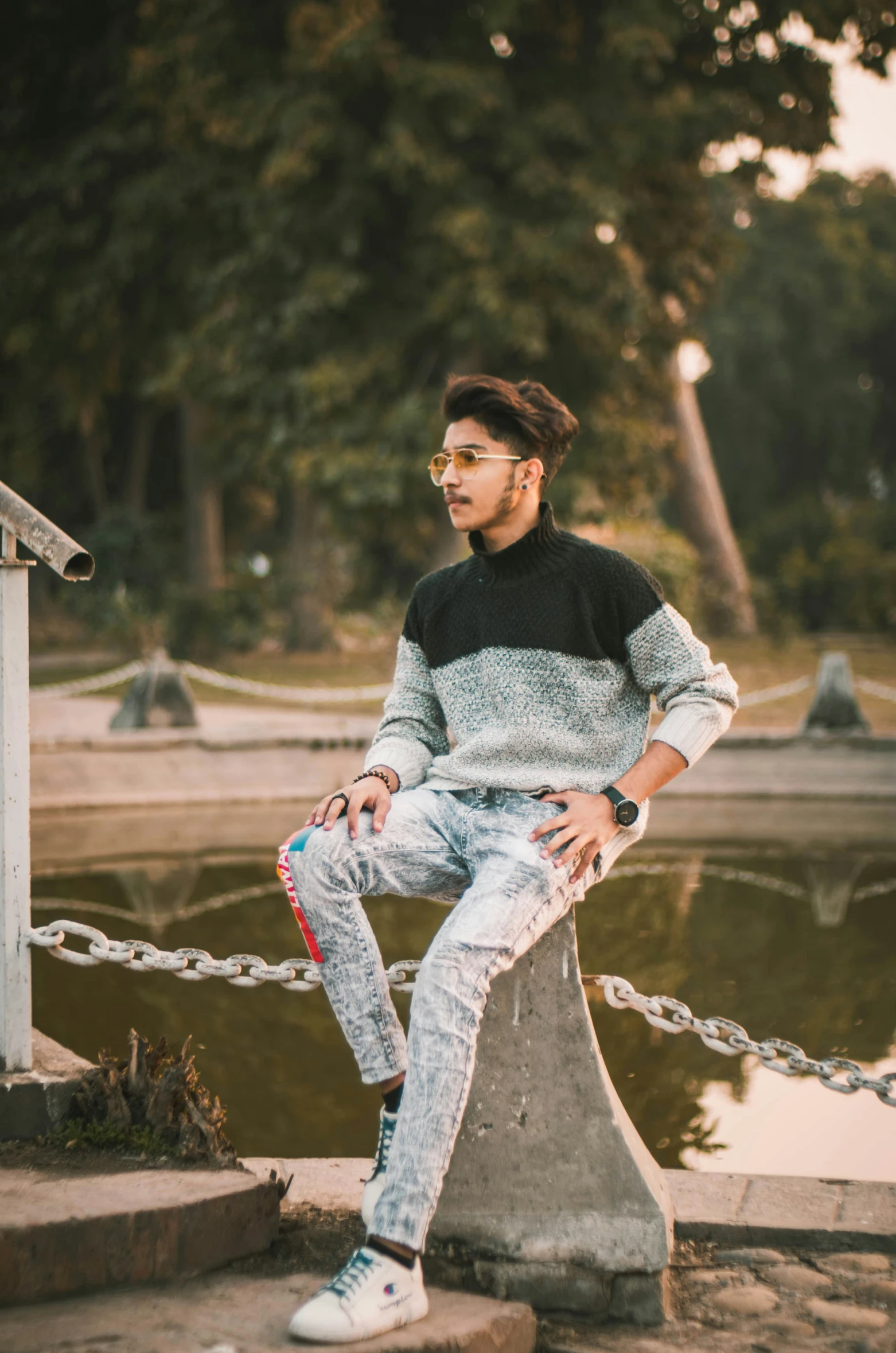 a young man in ripped jeans and a tee shirt posing for a picture